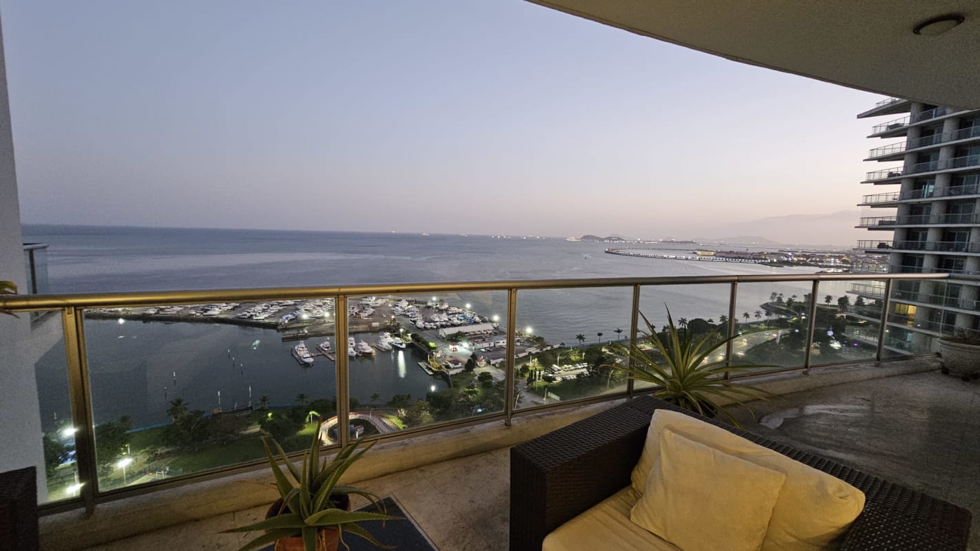 Modern balcony with panoramic ocean and marina views, glass railing, outdoor seating PH Sky Residence Panama City