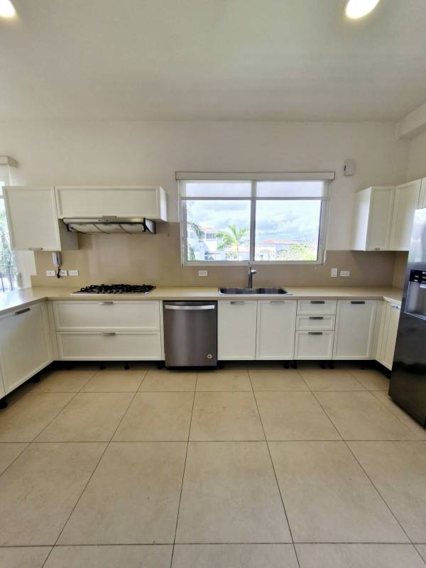 Contemporary kitchen with white cabinets, large windows and appliances in The Reserve Santa María