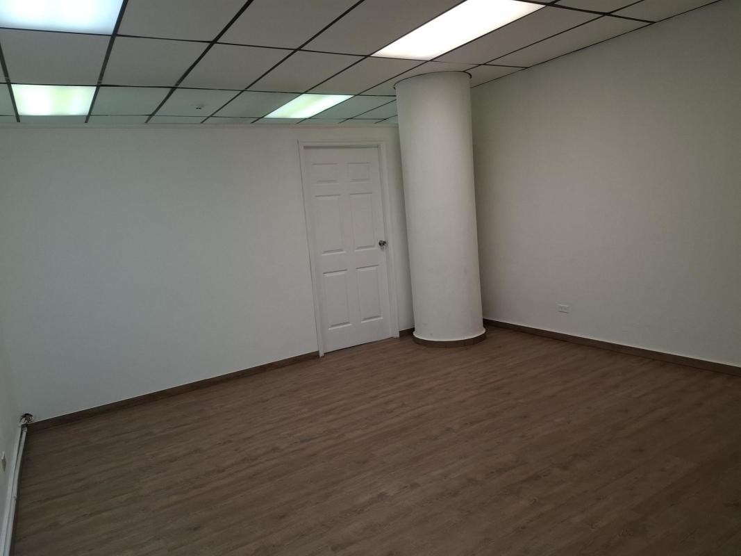 Empty office with support column, ceiling lights, wooden floor in Panama City
