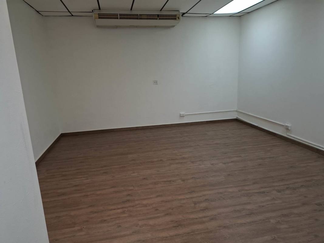 Empty commercial office with AC unit mount, wood floors, white walls Panama