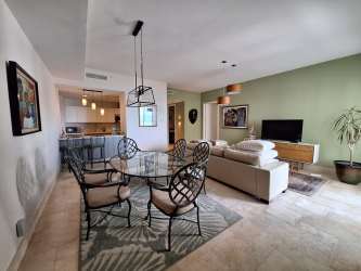 Double bed guest bedroom with closet, TV, and fan in luxury beachfront rental Buenaventura Puntarena Panama