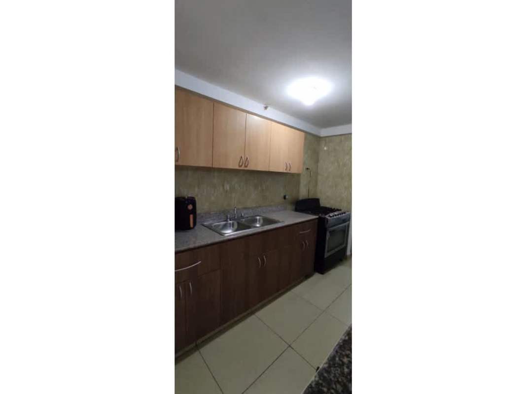 Modern kitchen with granite bar, wood cabinets, gas stove at PH Terrazas del Rey Panama City