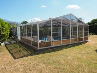 Screen enclosure over patio backyard pool tropical garden Cabuya Panama house
