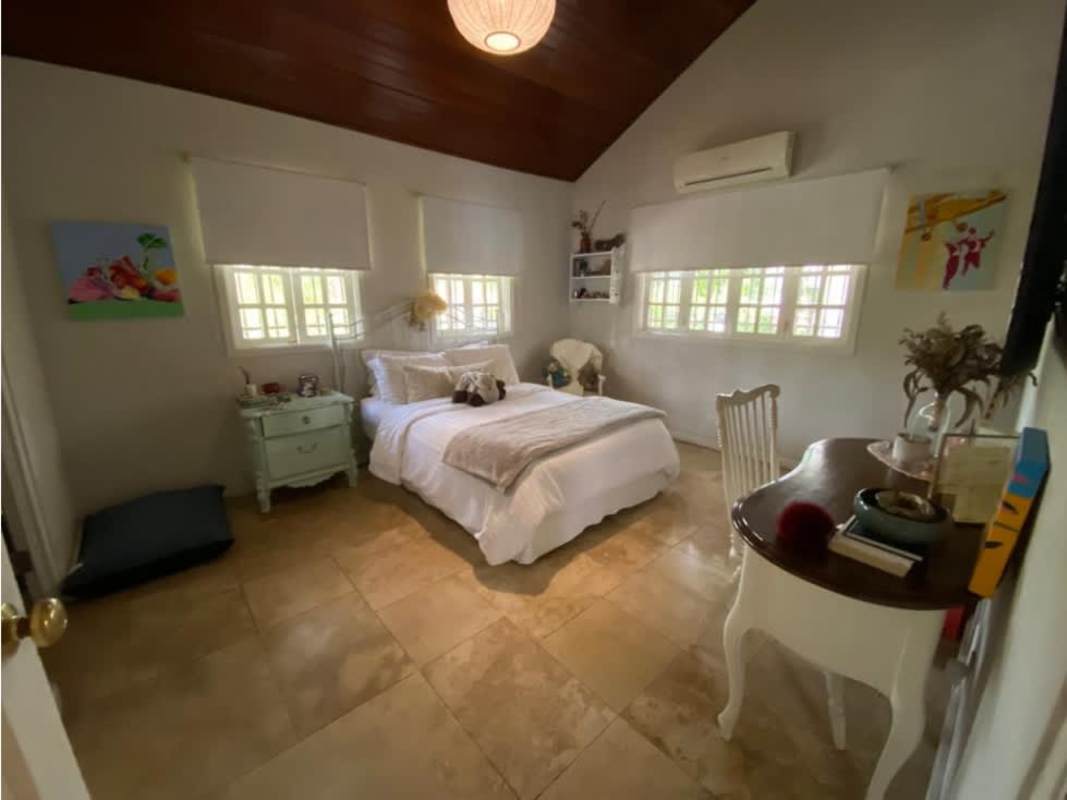 Master bedroom with vaulted ceiling, chandelier, and ensuite bath in Altos del Golf Panama City