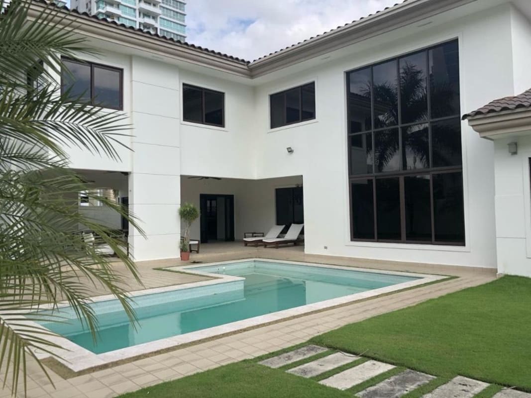 Contemporary kitchen with large granite island, wood cabinetry, stainless steel appliances in luxury house rental Costa del Este Panama City