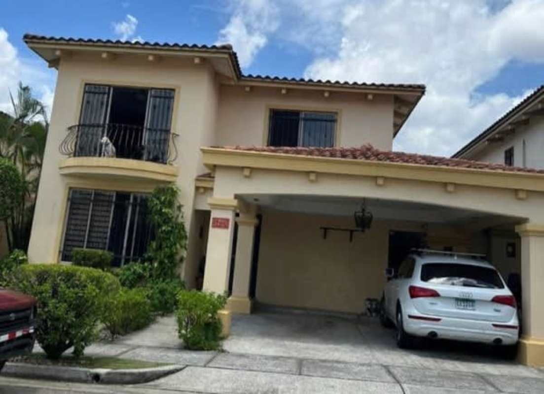 Two-story Mediterranean style home with tiled roof, balcony, covered parking