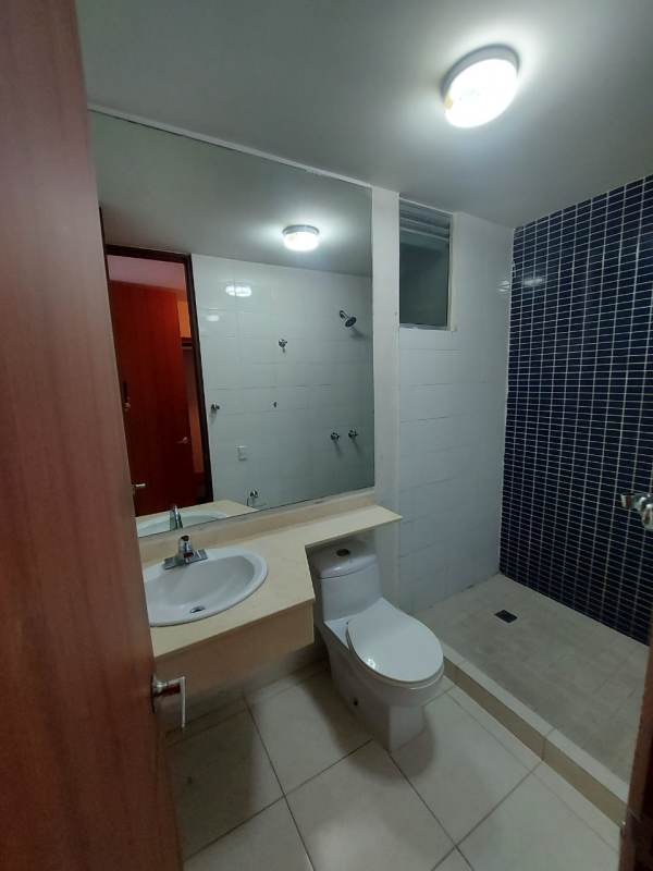 Bathroom with glass shower enclosure, sink and toilet in furnished apartment Panama City