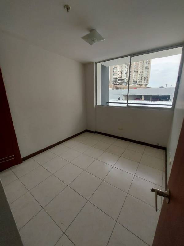 Bright living and dining room with balcony sliding doors at furnished apartment in El Bosque Panama City