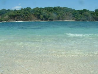 White sandy beaches with turquoise water and tropical forest backdrop on private island Veraguas Panama