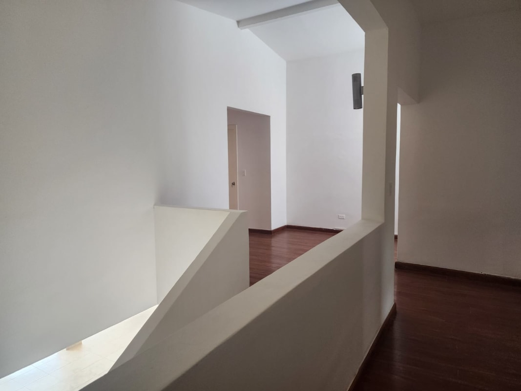 Minimalist hallway with wood floors and staircase in luxury house Coco del Mar