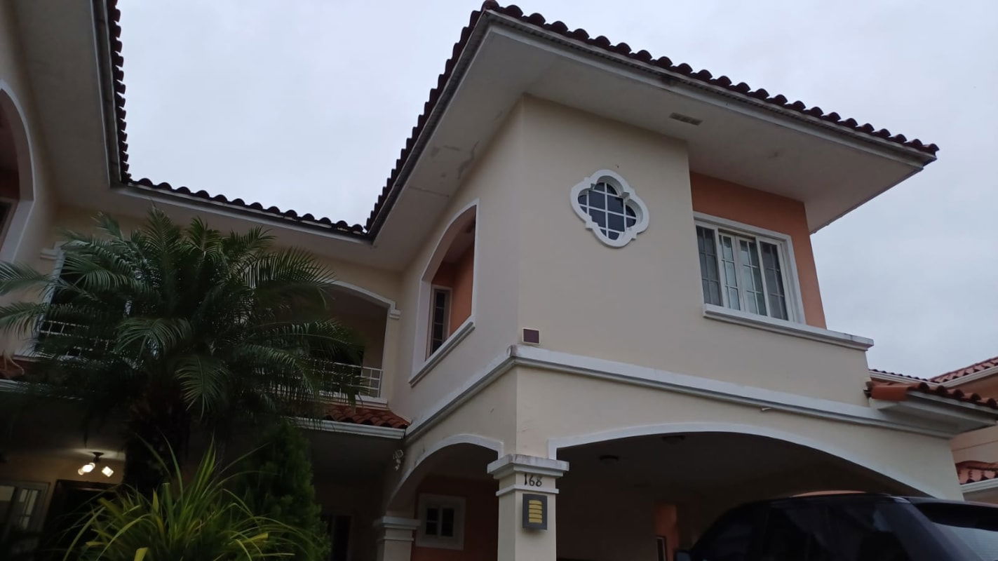 Mediterranean-style two-story house with balcony, cream walls, tile roof at Costa Sur Panama