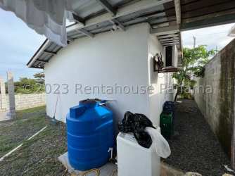 Side exterior with water storage tank and fenced yard La Chorrera house