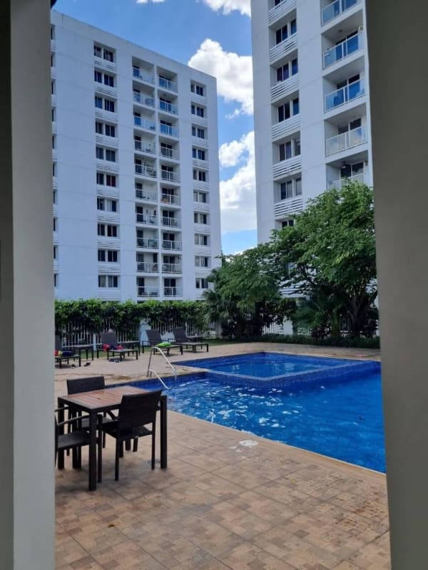 Outdoor pool surrounded by social areas and greenery at Torres de Cantabria complex Panama City