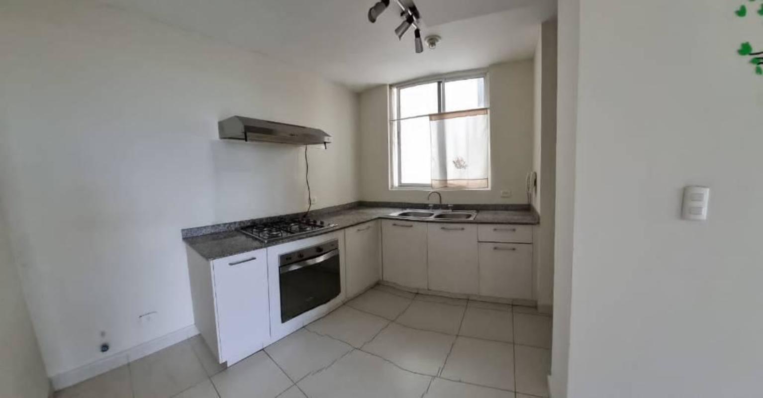Minimalist design kitchen with granite countertops, range hood, oven and gas cooktop in Panama apartment
