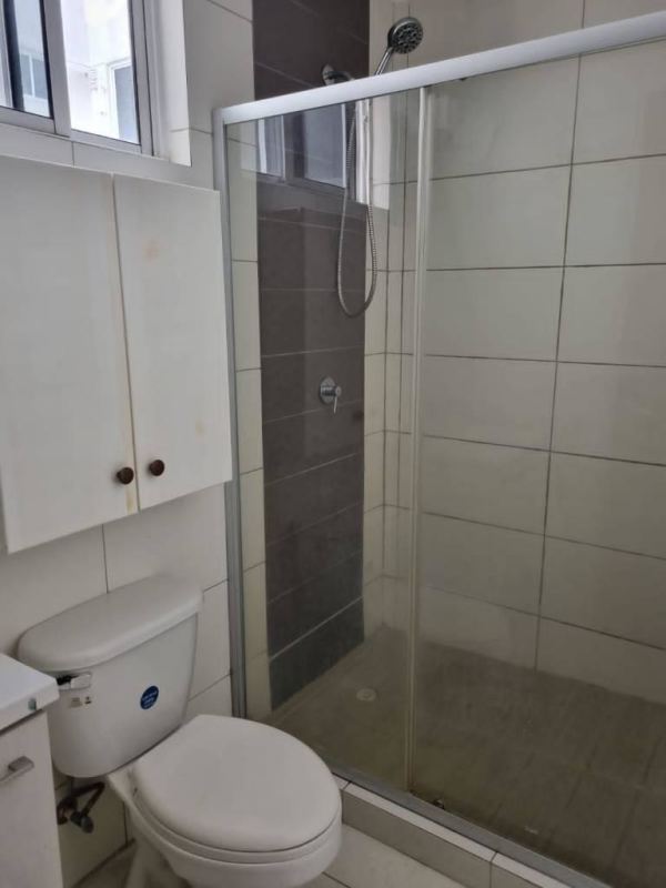 Bedroom with accent wall, ensuite bathroom, tile floor in Panama apartment at Torres de Cantabria