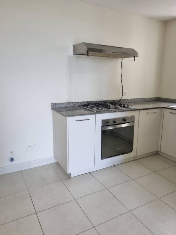 Modern compact kitchen with granite countertop, laundry area, and appliances in Torres de Cantabria Las Acacias