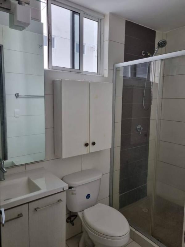 Updated bathroom with glass shower, ceramic tiles and window in Panama City apartment for sale