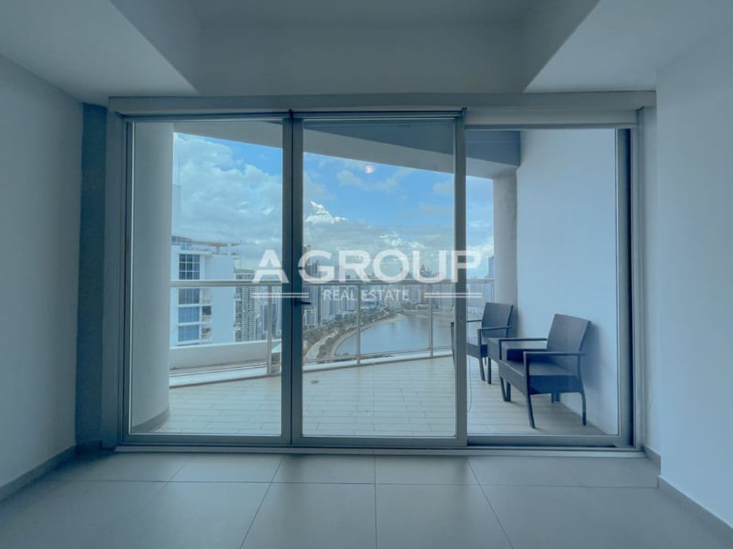 Bright living room with floor-to-ceiling glass doors leading to balcony, ocean and city views in Yacht Club Ave Balboa Panama