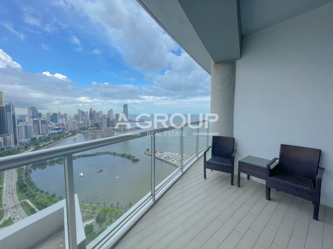 Living-dining room with sliding glass doors to balcony, ocean front vista at PH Yacht Club Panama