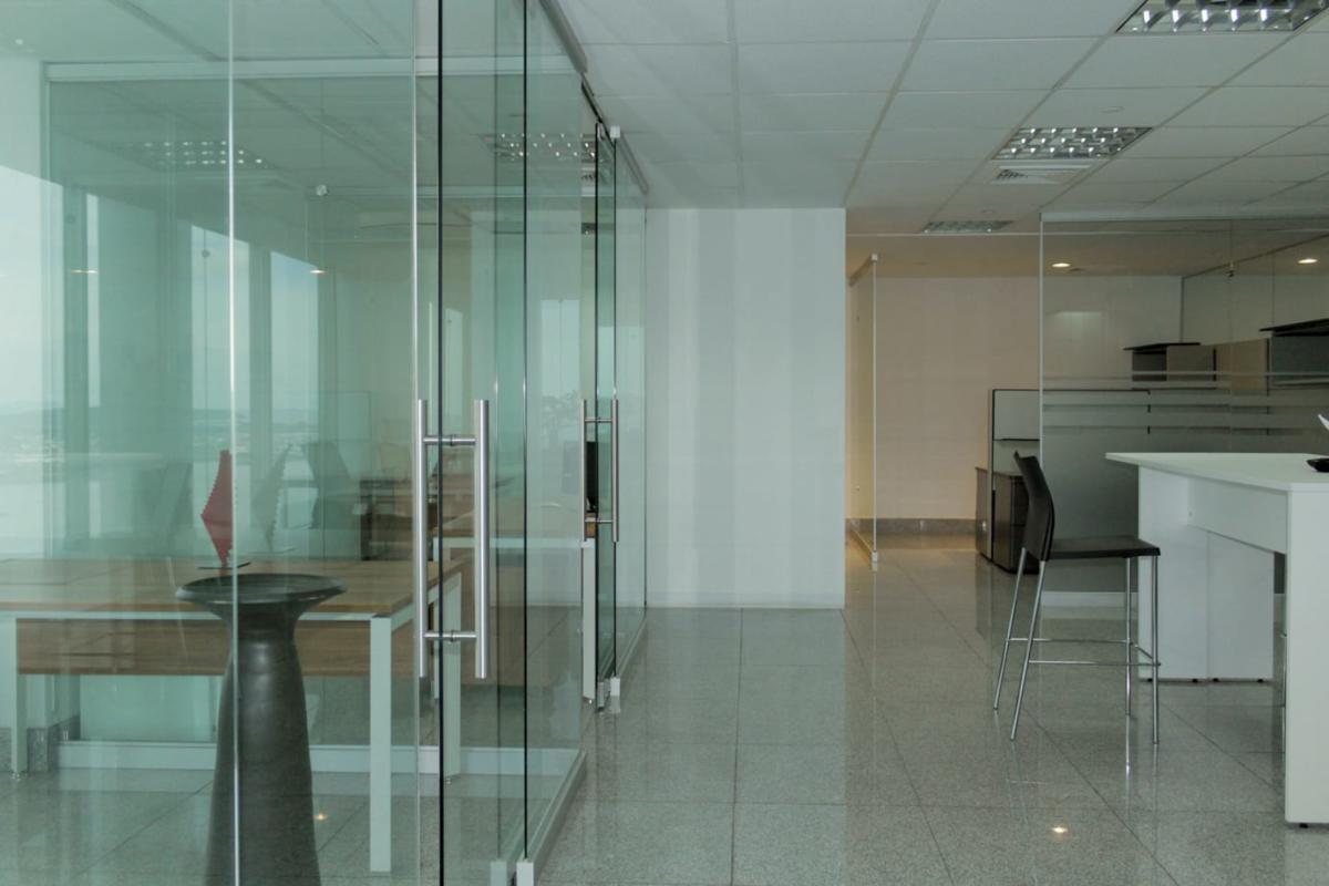 Modern office interior with glass enclosed workspaces tiled floor BICSA Panama