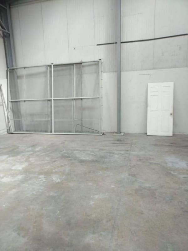 Warehouse space with high ceiling, exposed beams and concrete floor in Panama industrial area