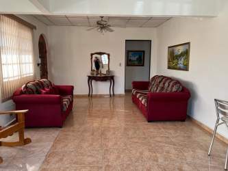 Living room with red sofas, tile floors and ceiling fan in furnished property Santiago Panama