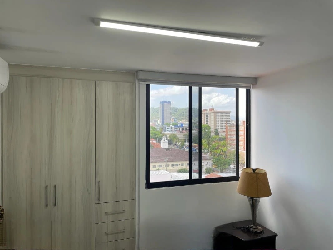 Bedroom with built-in closet, large window and tile flooring at PH Balboa Bay La Exposición Panama City