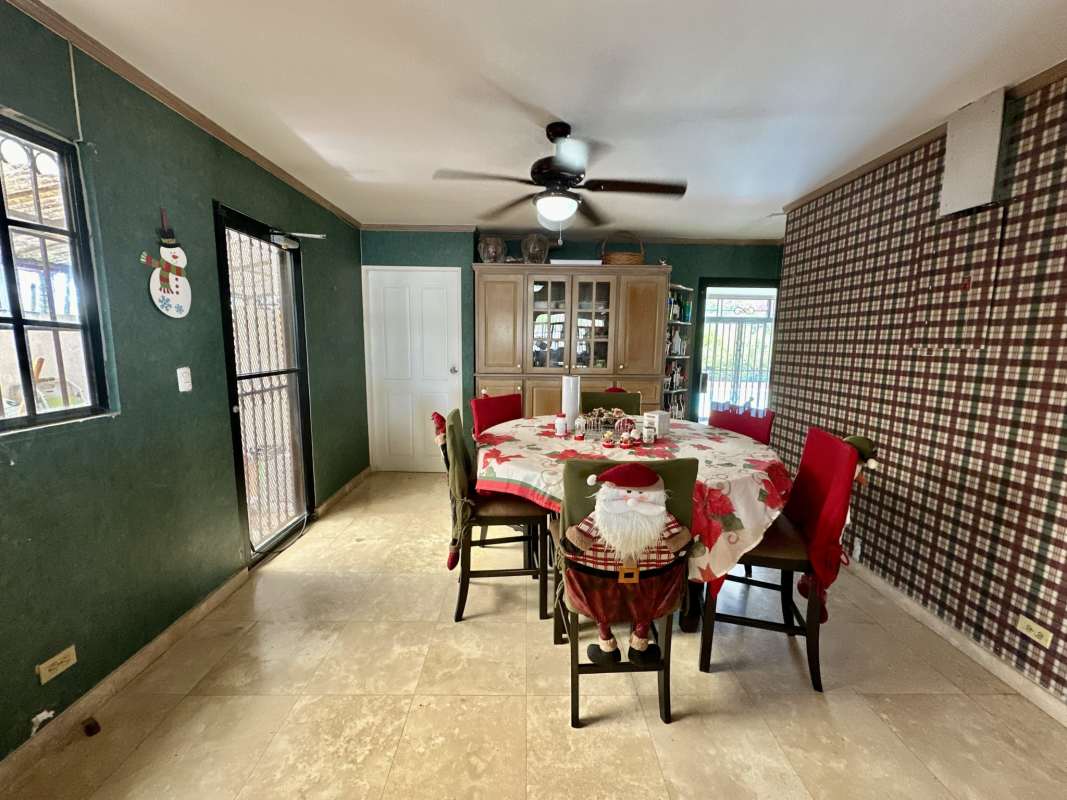 Dining area decorated festive, green walls, round table seating Las Cumbres Panama