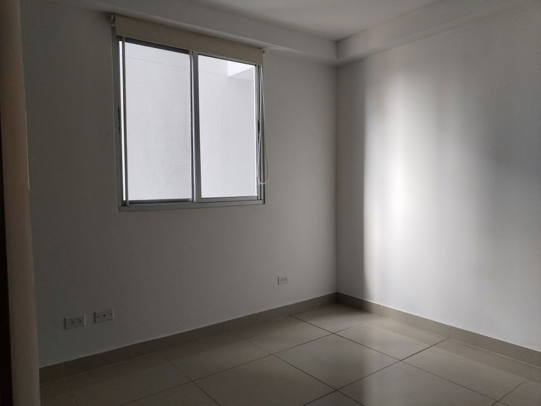 Minimalist bedroom with tiled floor and large window in PH Coral Towers Panama City for sale