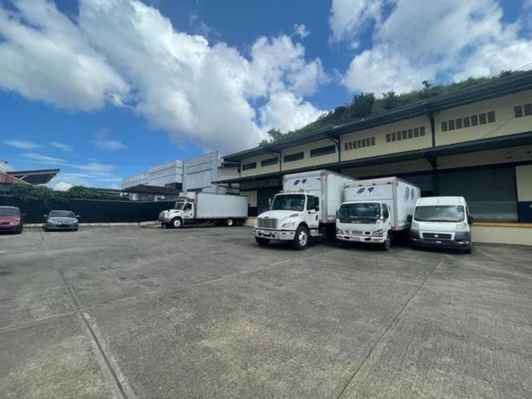 Exterior with delivery trucks, loading docks and parking at warehouse complex in El Crisol