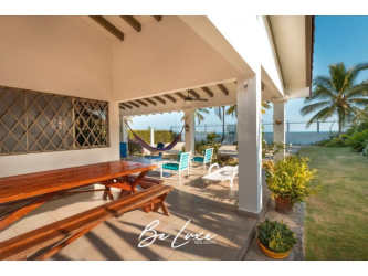 Covered terrace patio with garden and oceanfront views in Farallón beach house Panama