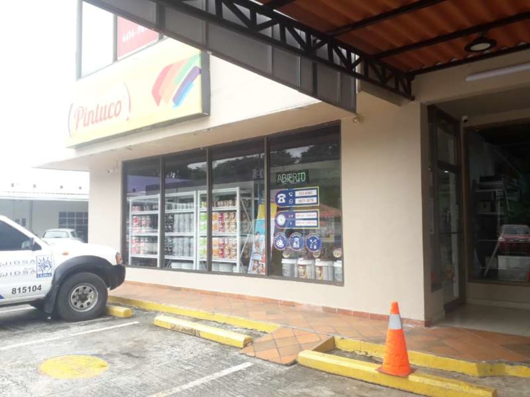 Retail storefront exterior with glass windows, parking area and store signage in Albrook Panama