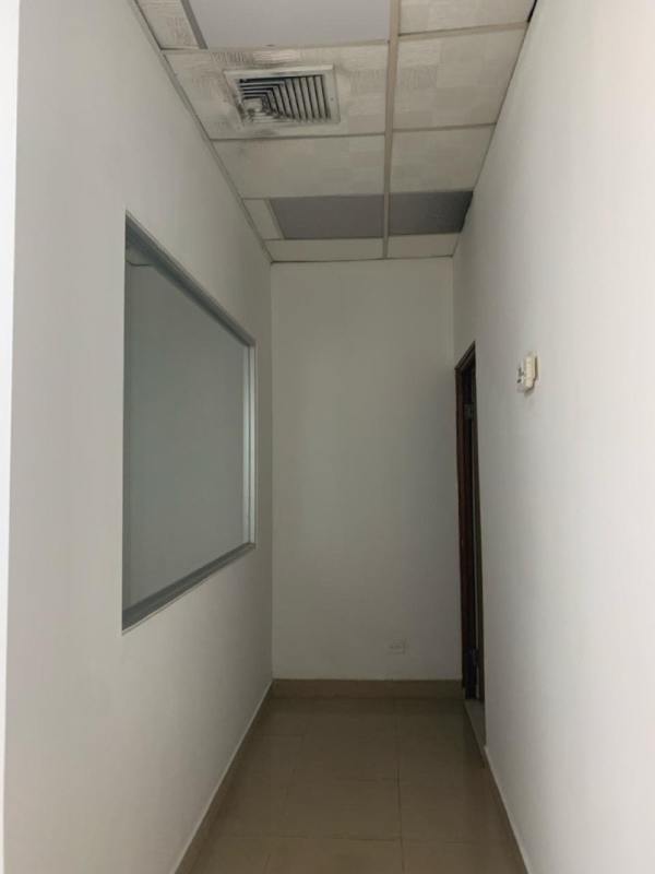 Interior corridor with white walls, drop ceiling tiles and office layout in Via España commercial center Panama