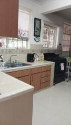 Kitchen with double sink, tile backsplash, natural light in Howard Panama Pacifico home