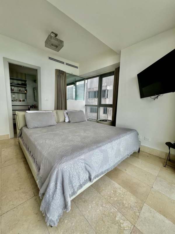 Open plan dining area with marble table adjacent modern kitchen in Yoo Panama