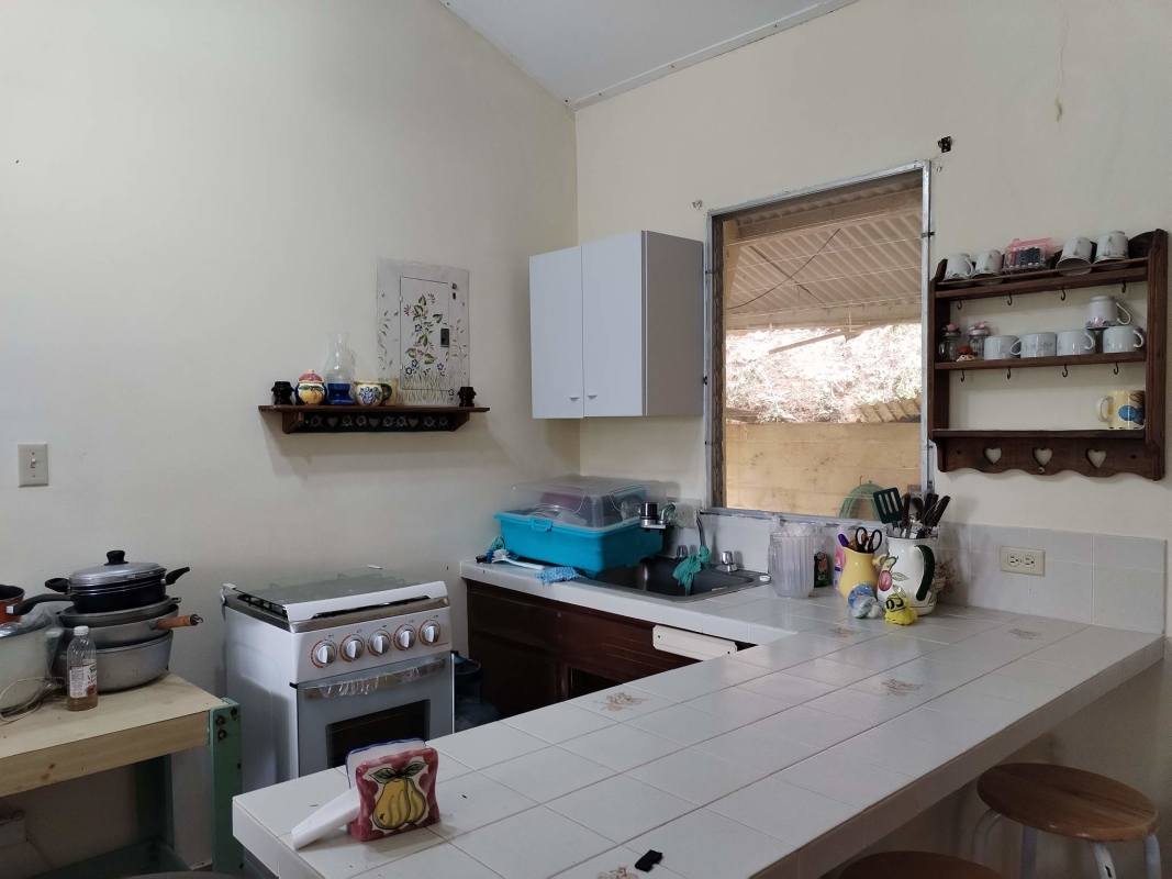 Traditional kitchen with tiled counter and large window mountain house Altos del Alcázar Cerro Azul Panama for sale