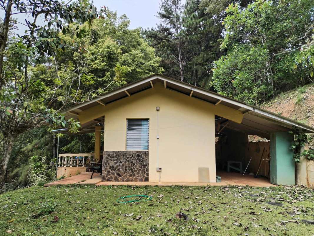 Yellow single-family mountain home with metal roof surrounded by lush forest Cerro Azul Panama real estate