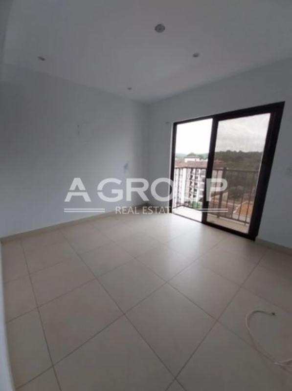 Modern living room with large sliding glass doors tiled floors balcony Embassy Village Clayton Panama