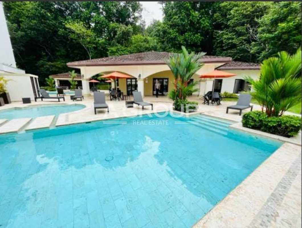 Large swimming pool jacuzzi sun loungers lush gardens Embassy Village Clayton Panama