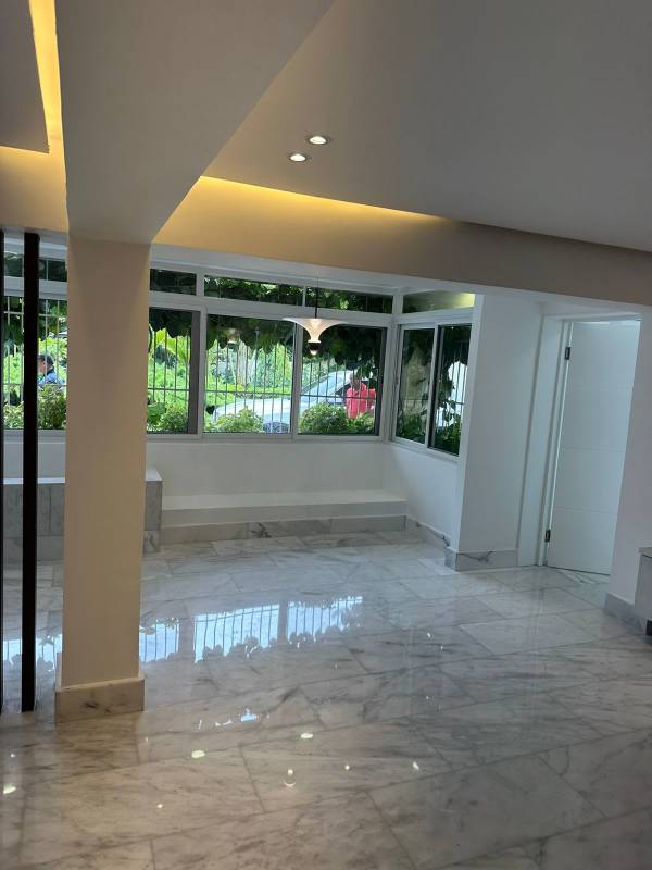 Bright living space with marble floors, large windows, garden view in Altos del Golf luxury house