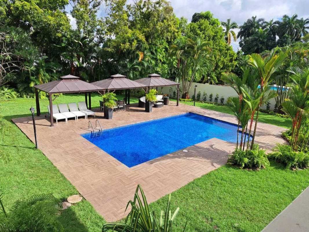 Upscale walk-in closet with marble flooring, built-in shelving, accent wall in Altos del Golf luxury residence
