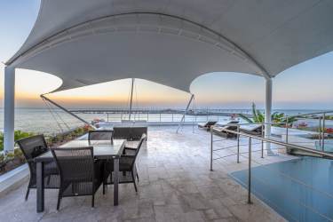 Infinity swimming pool with tropical palm trees and luxury deck in Vista Mar villa Panama