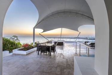 Covered outdoor kitchen area with BBQ and dining overlooking the ocean at Vista Mar villa