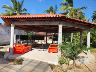 Open-air bohio tropical pavilion with red tile roof at luxury beach estate Nueva Gorgona