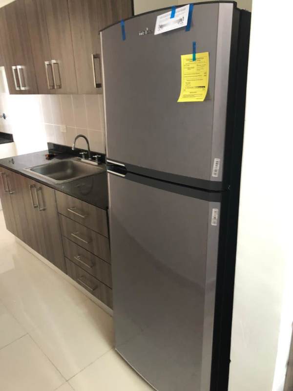 Modern kitchen with granite counters, refrigerator, tile backsplash PH Residencias del Sol Panama