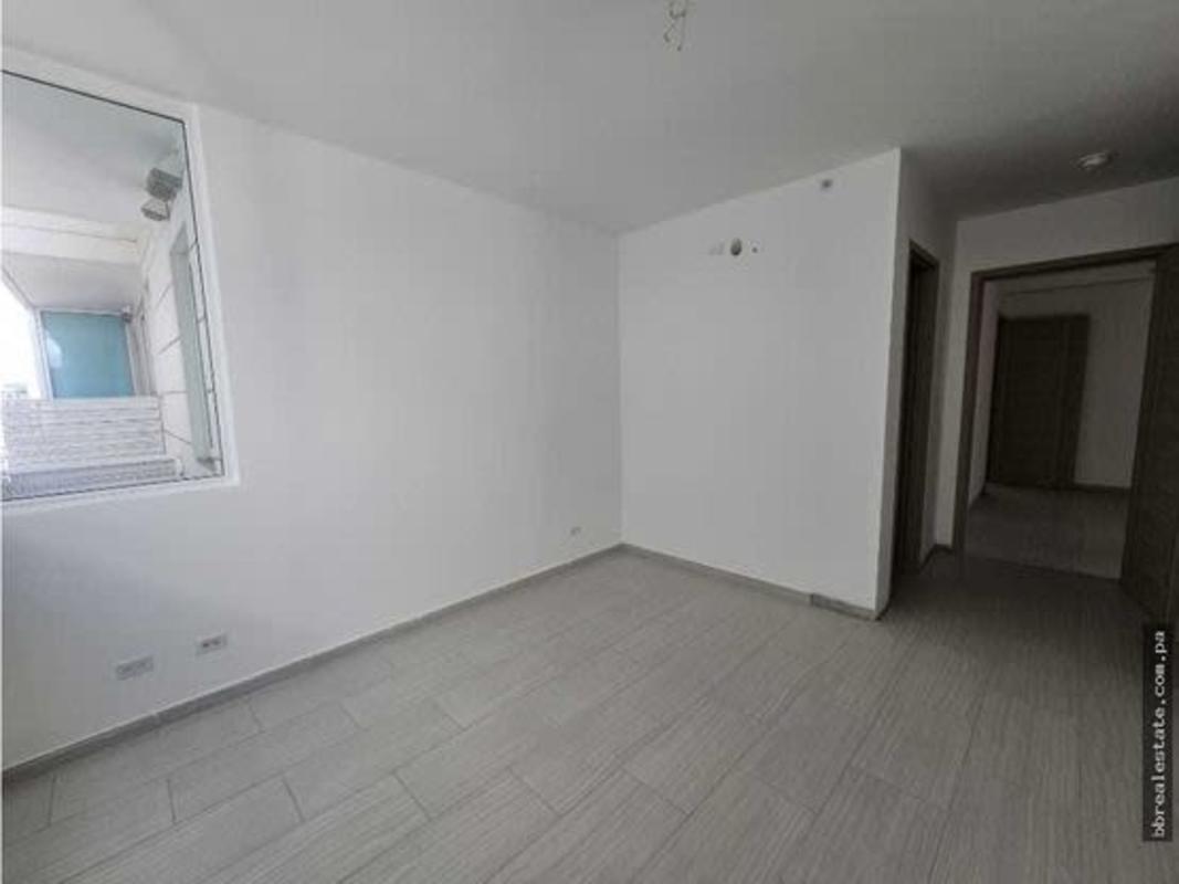 Modern bedroom with large window overlooking Panama City skyline at PH The Towers San Francisco