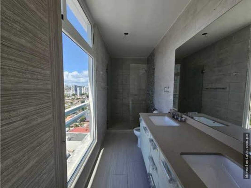 Contemporary kitchen with cabinetry, double sink and tile backsplash in PH The Towers luxury apartment Panama