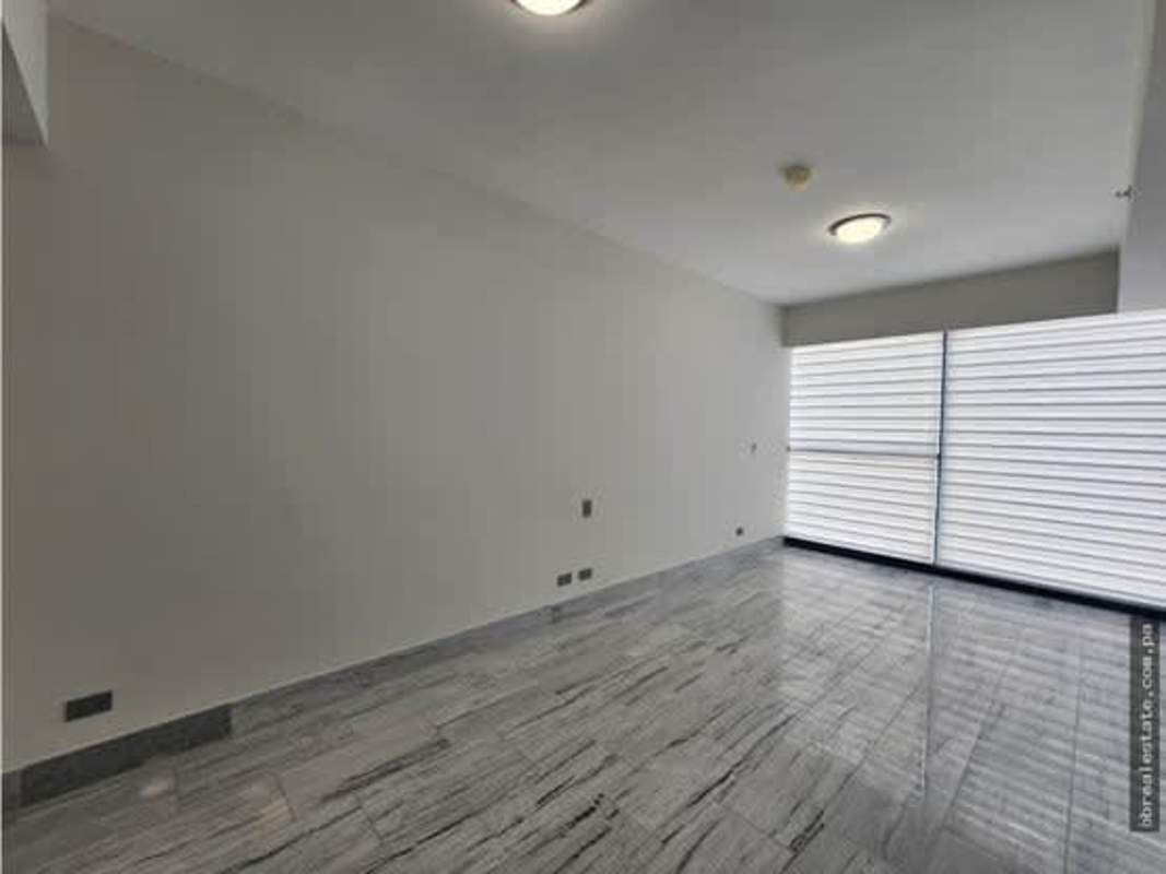 Open-plan dining and living leading to balcony overlooking Panamá skyline at Nuovo by Armani