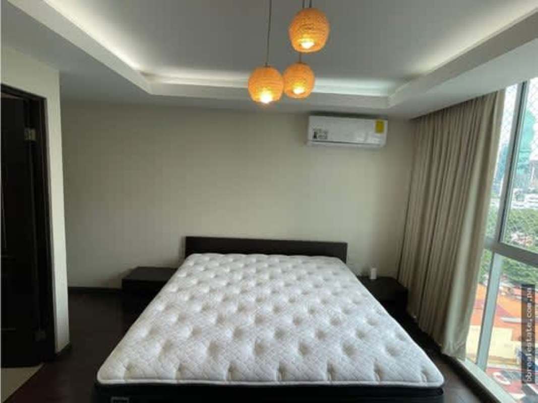 Bedroom with large window city view minimalist decor PH Sun & Sky Punta Pacifica Panama