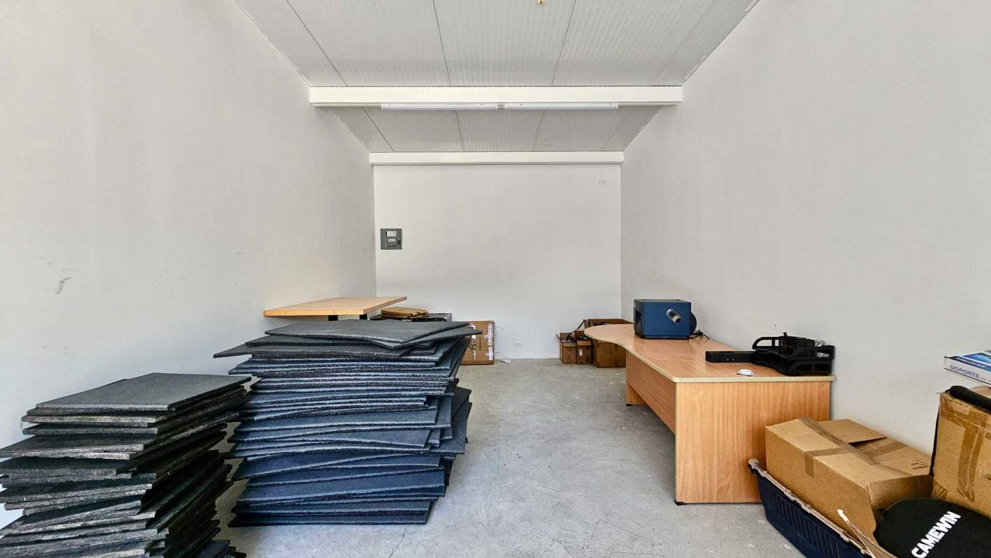 Unfinished utility/storage area with stacked materials inside Jackie's Padel Commercial unit Chanis